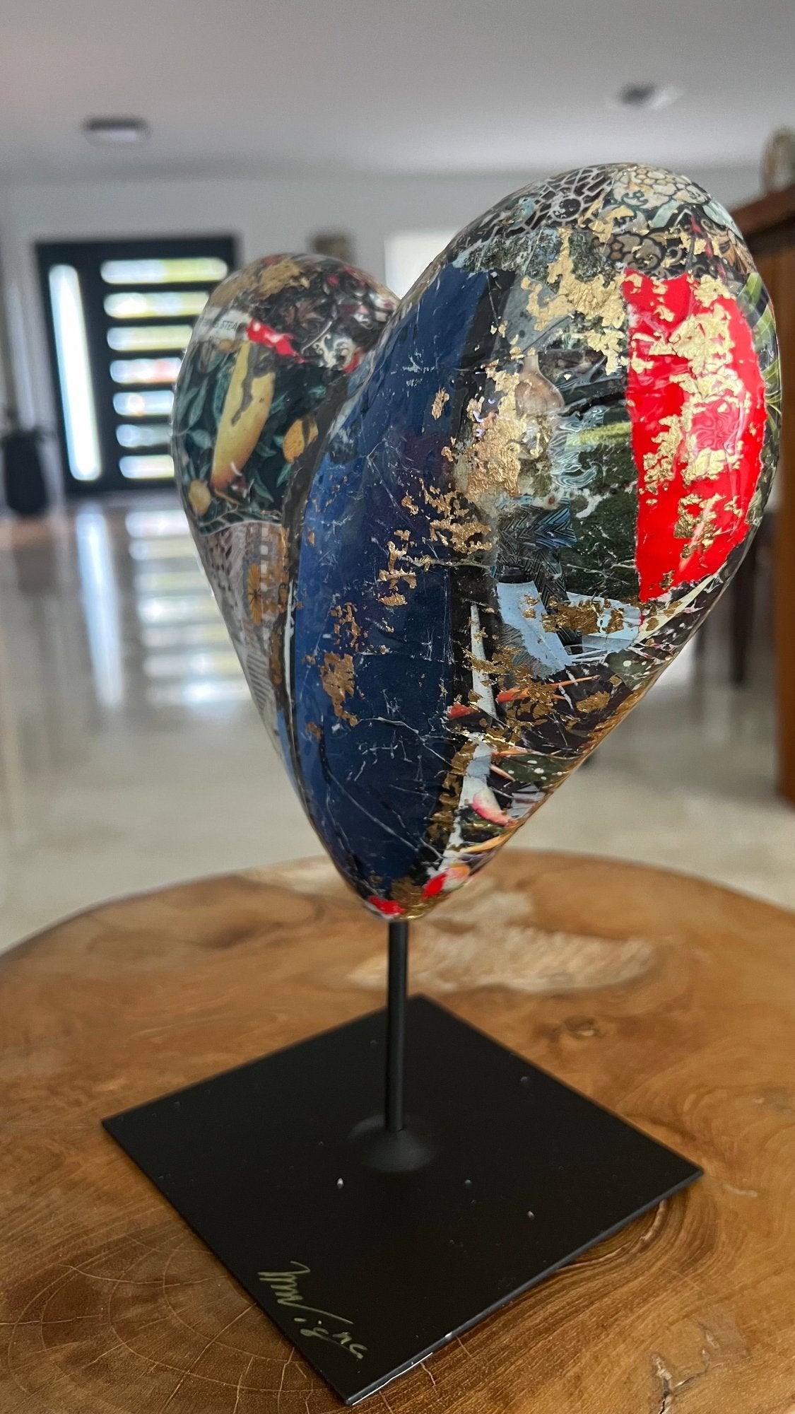 Colorful heart sculpture with a combination of collage, gold leaf, and abstract designs